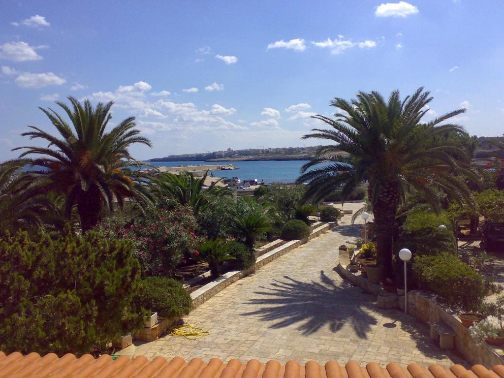 a view of a street with palm trees and the ocean at Ville Alba & Azzurra in Polignano a Mare