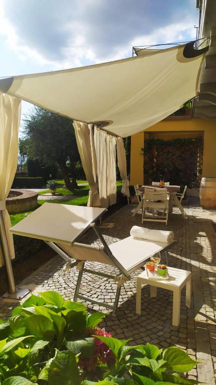 patio z krzesłami, stołem i parasolem w obiekcie La Morra Suite w mieście La Morra