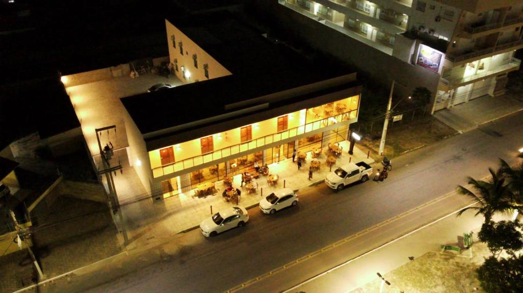 a group of cars parked outside of a building at night at Pousada BarbacoaR in Parnaíba