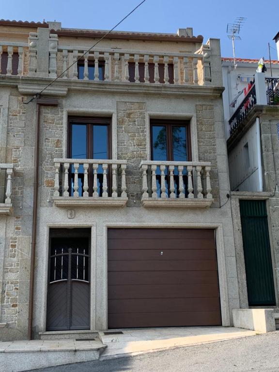 a house with a garage and a balcony at La Casa de la Abuela in A Pobra do Caramiñal