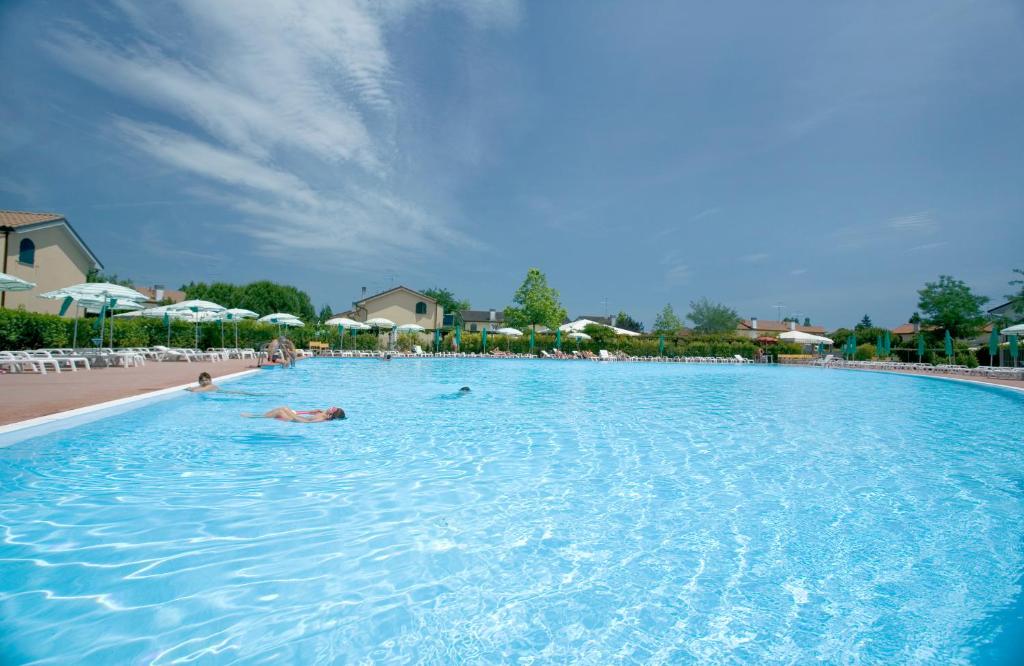 un grupo de personas nadando en una gran piscina en Villaggio Teodorico, en Punta Marina