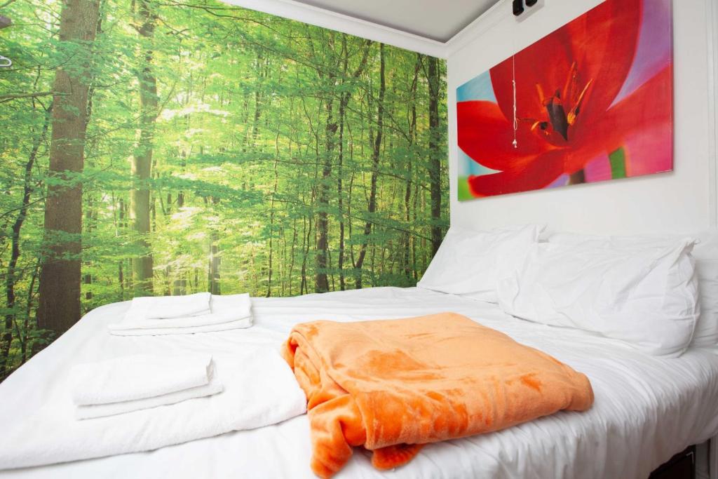 Schlafzimmer mit einem Bett mit Wandgemälde in der Unterkunft Cosy Studio in the Heart of Trendy Kemptown in Brighton & Hove