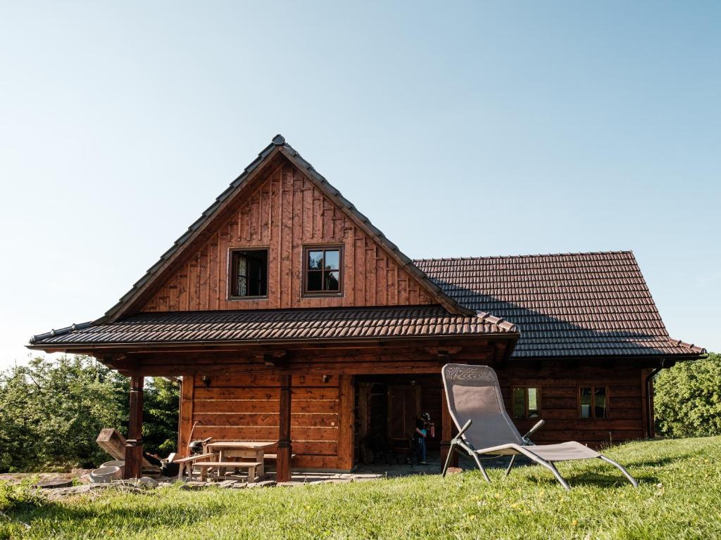 a log cabin with two lawn chairs in front of it at Statek Humenec - Klid u lesů, Česko in Valašská Bystřice
