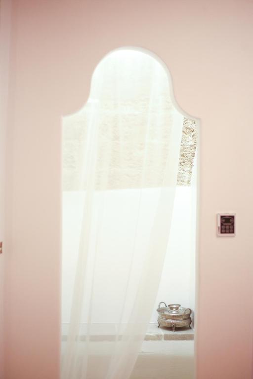 a window with a white curtain in a room at CORTE LARGO LAURO DIMORE & SPA in Gemini