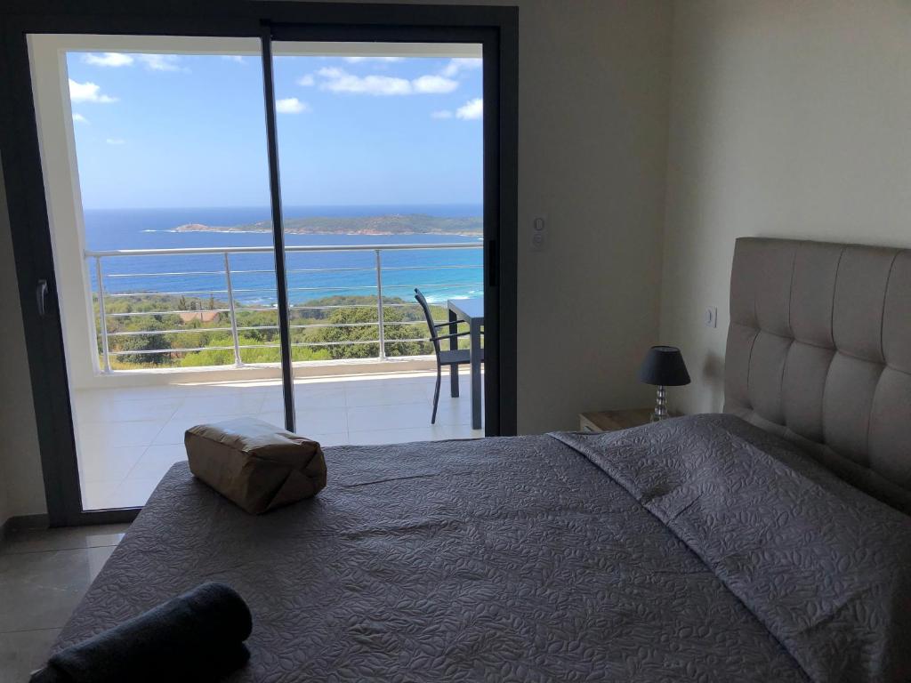 a bedroom with a bed and a view of the ocean at Appartement 140M2 villa cargèse in Cargèse