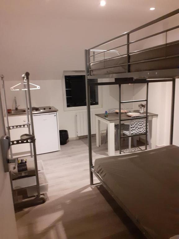 Zimmer mit einem Etagenbett und einer Küche mit einem Schreibtisch in der Unterkunft CHAMBRES ESTREES in Estrées