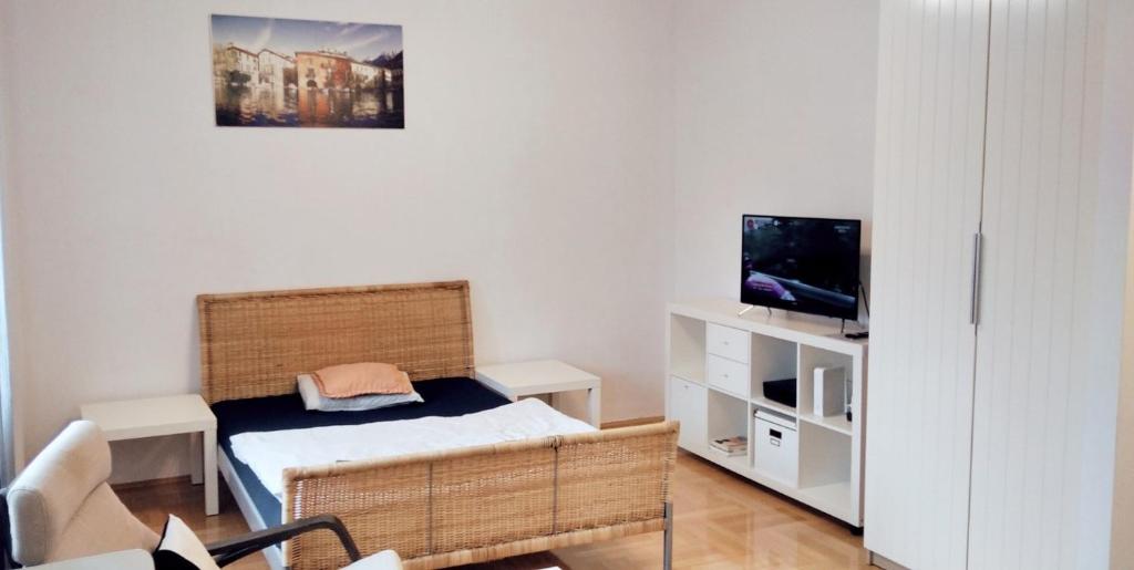 Kleines Zimmer mit einem Bett und einem TV in der Unterkunft apartament Hallera Square Warsaw 27m2 in Warschau