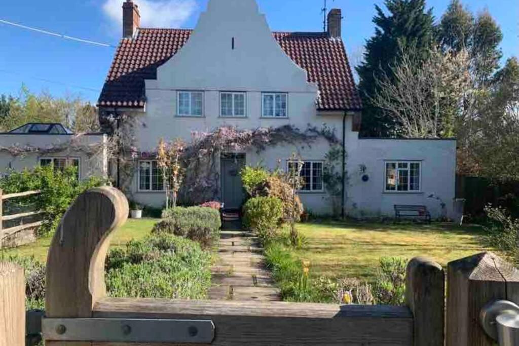 a house with a fence in front of it at Pretty country family home- dog friendly. in Henfield