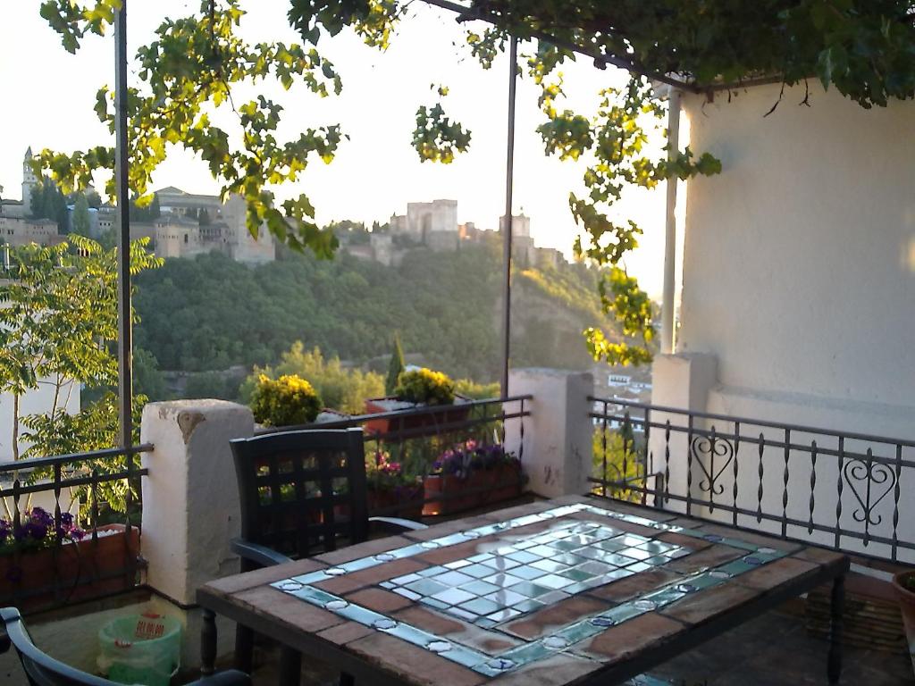 a table on a balcony with a view of the city at Apartamentos miradores de granada in Granada