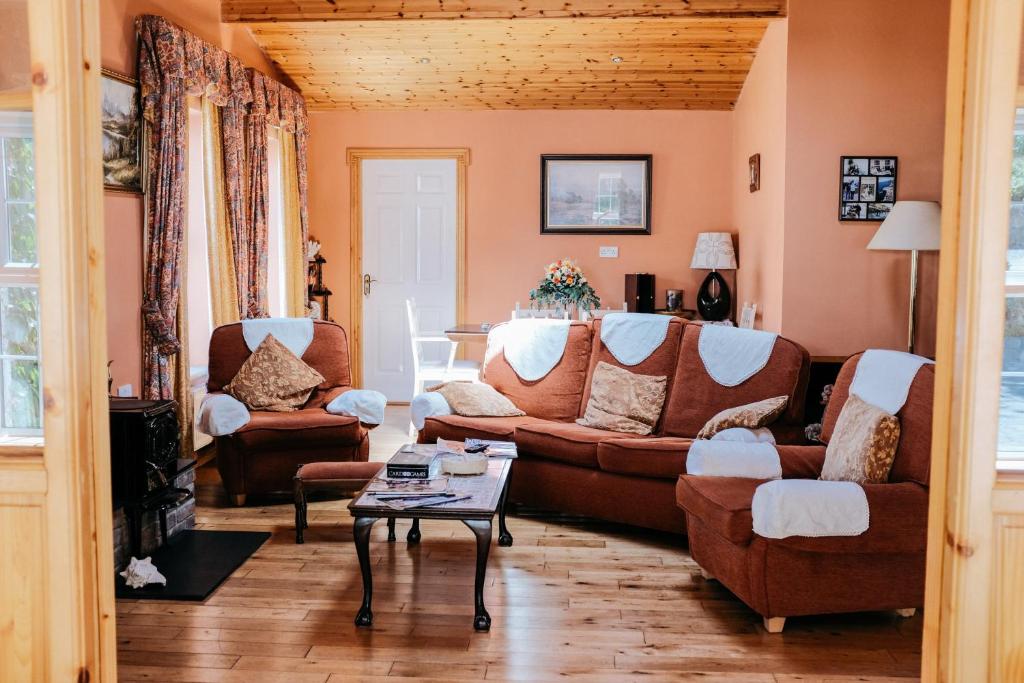 a living room with a couch and chairs and a table at Glenhill B&B in Wexford