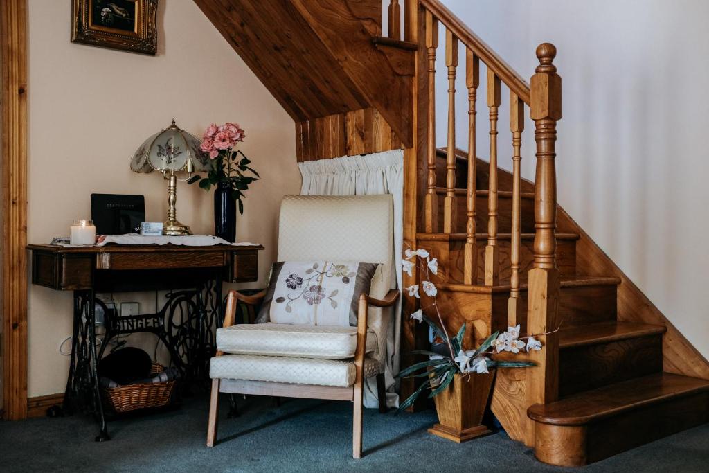 a chair and a desk in a room with a staircase at Glenhill B&B in Wexford