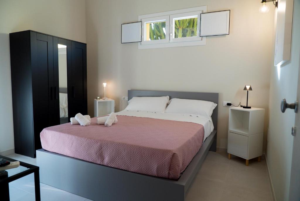 a bedroom with a large bed with a pink blanket at Civico 33 in Scalea