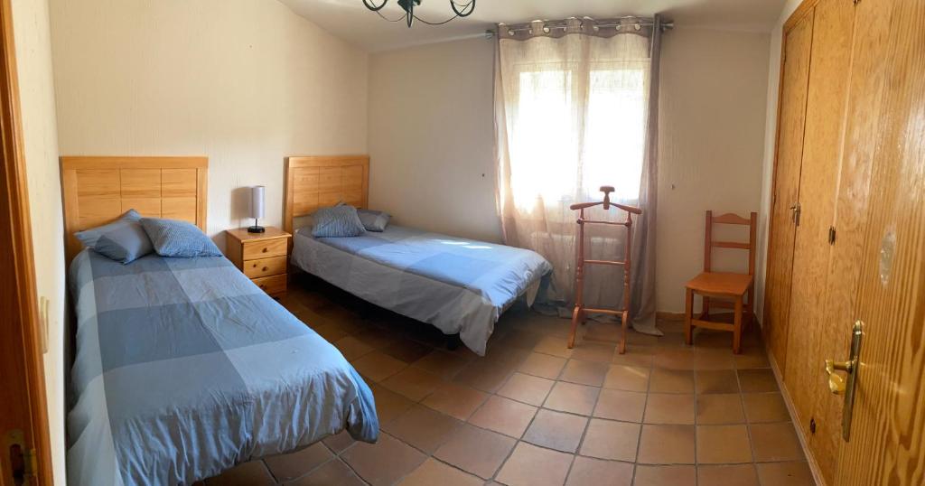 sypialnia z dwoma łóżkami i oknem w obiekcie Sierra Norte w mieście Canencia