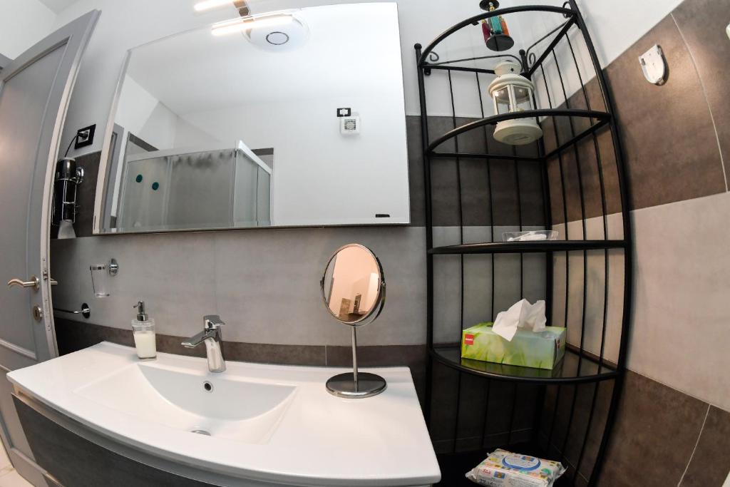 a bathroom with a sink and a mirror at "DueEmme Lodge" , a pochi passi dal porto in Livorno