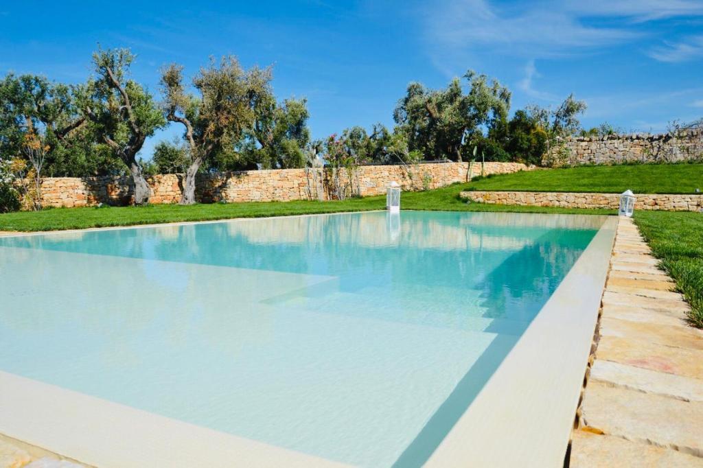 a large swimming pool with blue water at Augusta Trulli Resort in Polignano a Mare