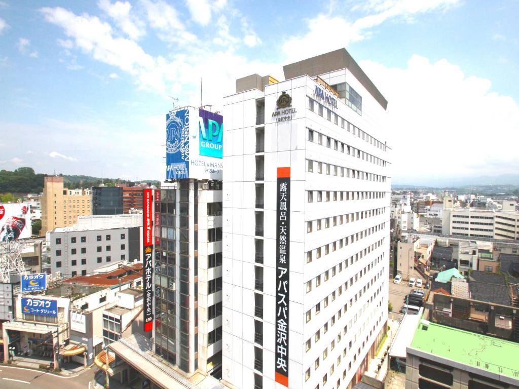 ein hohes weißes Gebäude mit einem Schild darüber in der Unterkunft APA Hotel Kanazawa Chuo in Kanazawa