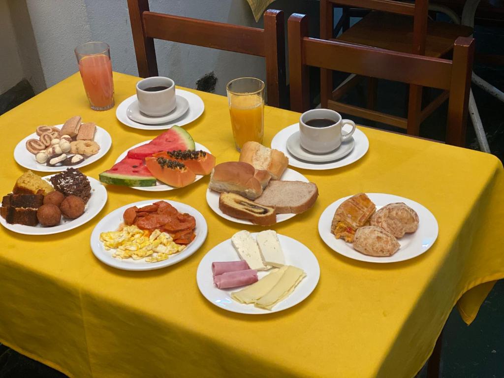 a table with plates of different types of food at Pousada e Chalés Arco-Íris in Lima Duarte