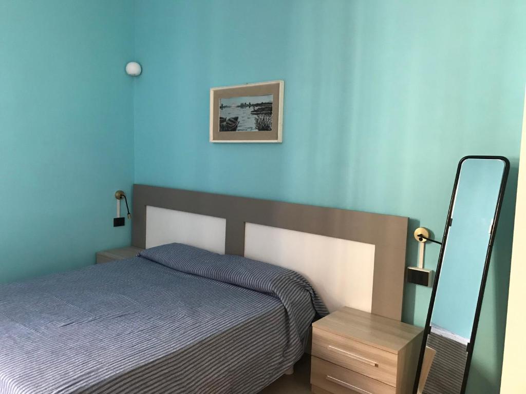 um quarto com uma cama e uma parede azul em Appartamento Gloria em Cremona