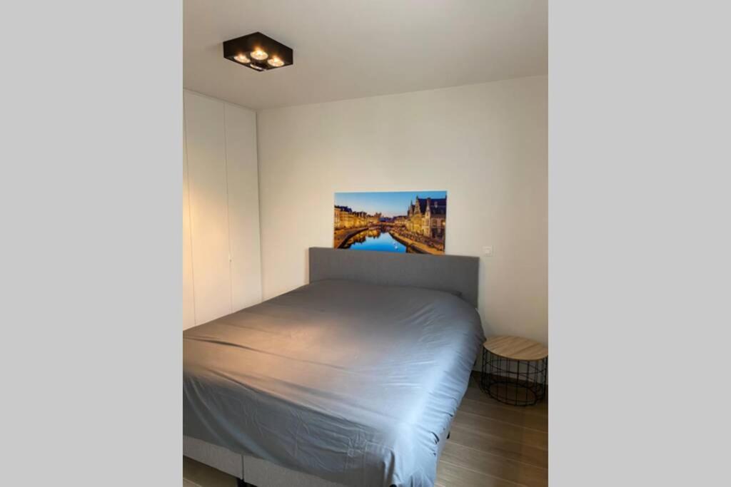 1 dormitorio con 1 cama y un puente en Schitterend nieuwbouw appartement in Gent, en Gante