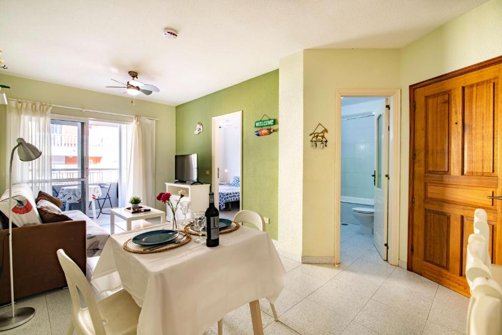 sala de estar con mesa y sala de estar en Alquilaencanarias- Medano Apartment Bogavante, en El Médano