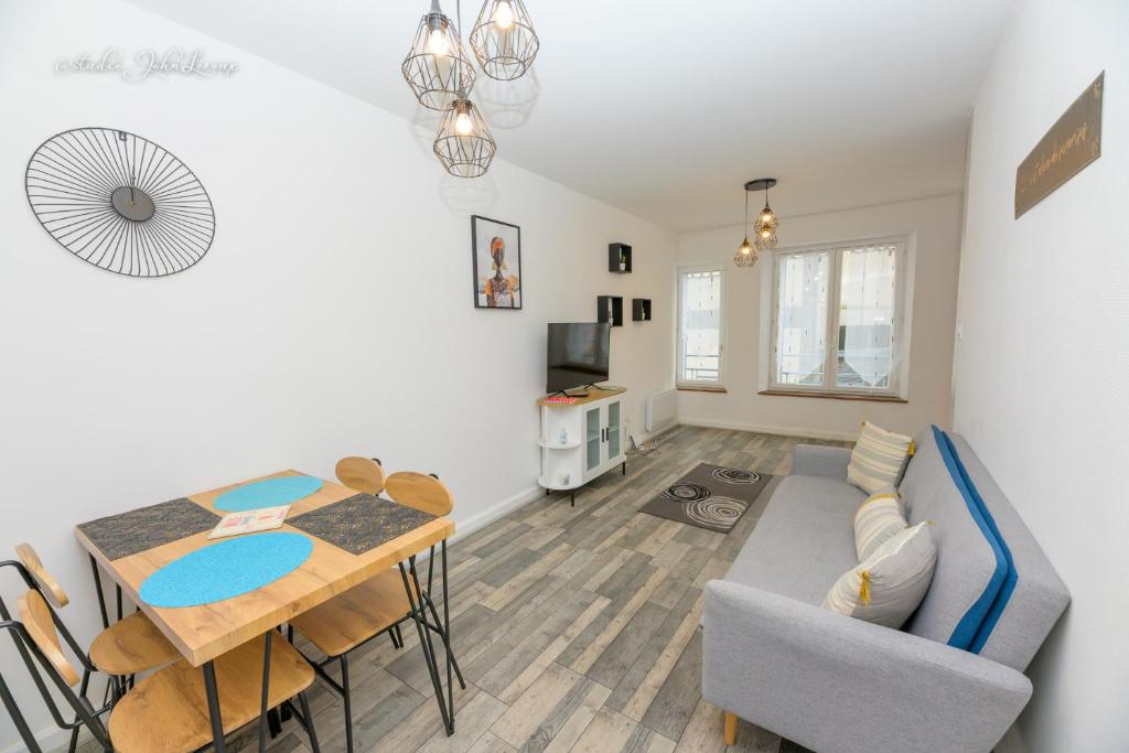 uma sala de estar com uma mesa e uma sala de jantar em Agreable et moderne appartement Toul centre em Toul