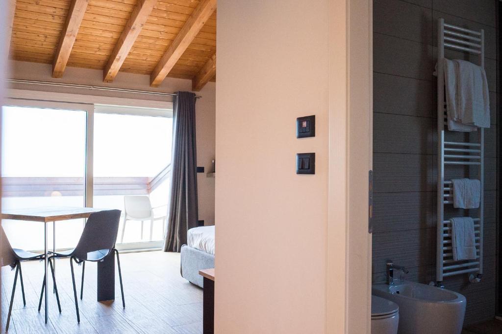 a living room with a table and a room with a window at Encanto Agriturismo & Private SPA in Visogliano