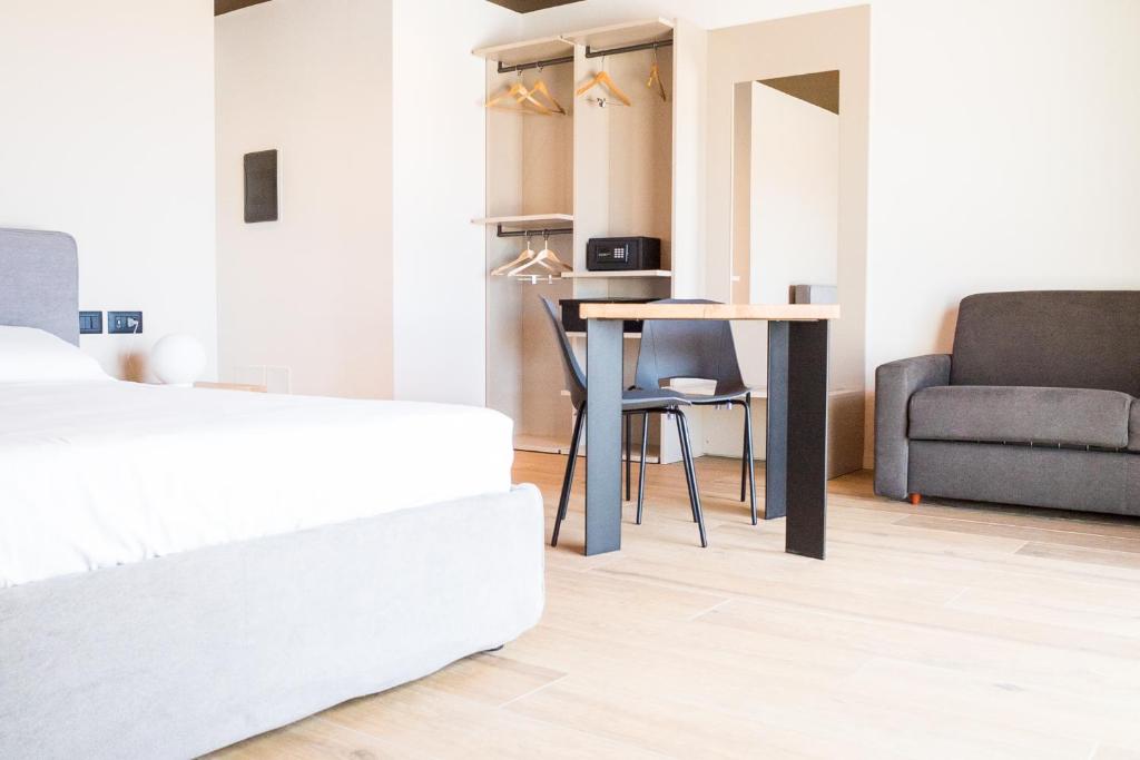 a bedroom with a bed and a table and a couch at Encanto Agriturismo & Private SPA in Visogliano