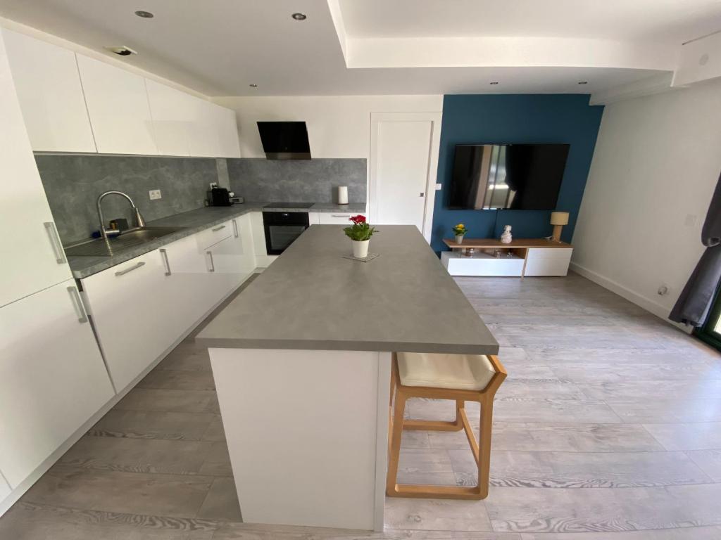 a kitchen with white cabinets and a counter top at Appartement Golf International de la Baule in Saint-André-des-Eaux