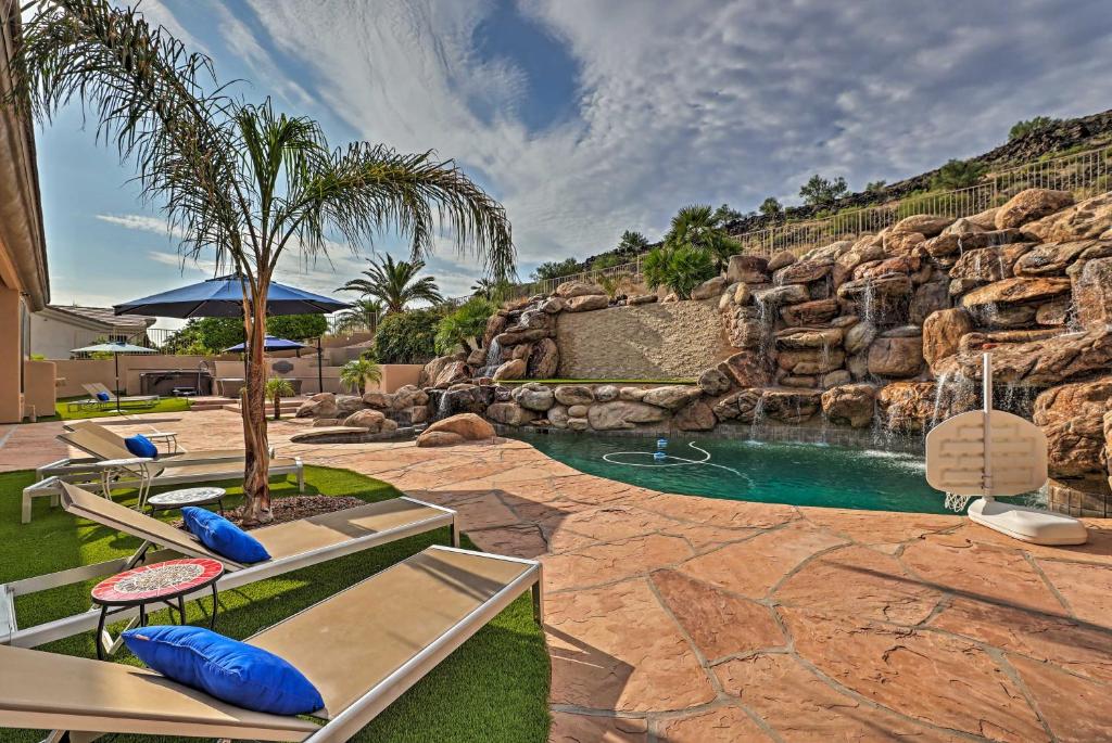 a pool in a resort with chairs and a waterfall at Pet-Friendly Glendale Oasis with Pool and Hot Tub! in Phoenix
