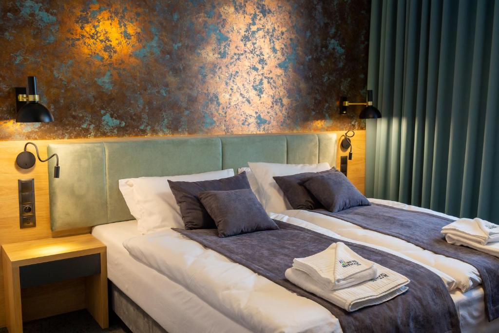 duas camas num quarto de hotel com paredes azuis em Hotel & SPA Hetman em Siedlce