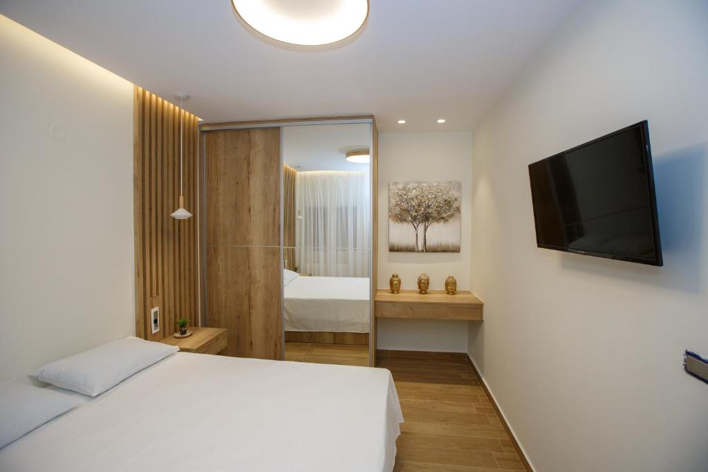 a bedroom with a bed and a television on a wall at Marianthe Apartments Ap2 in Ioannina