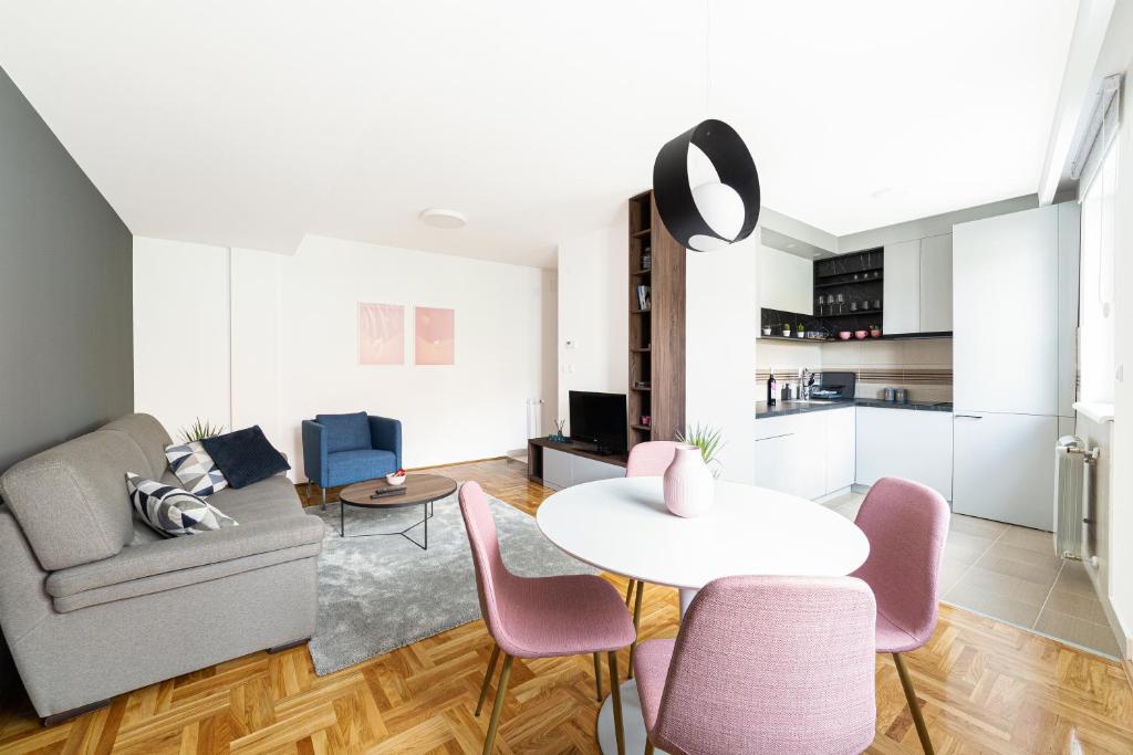 a living room with a couch and a table and chairs at Djokic Apartments in Kragujevac