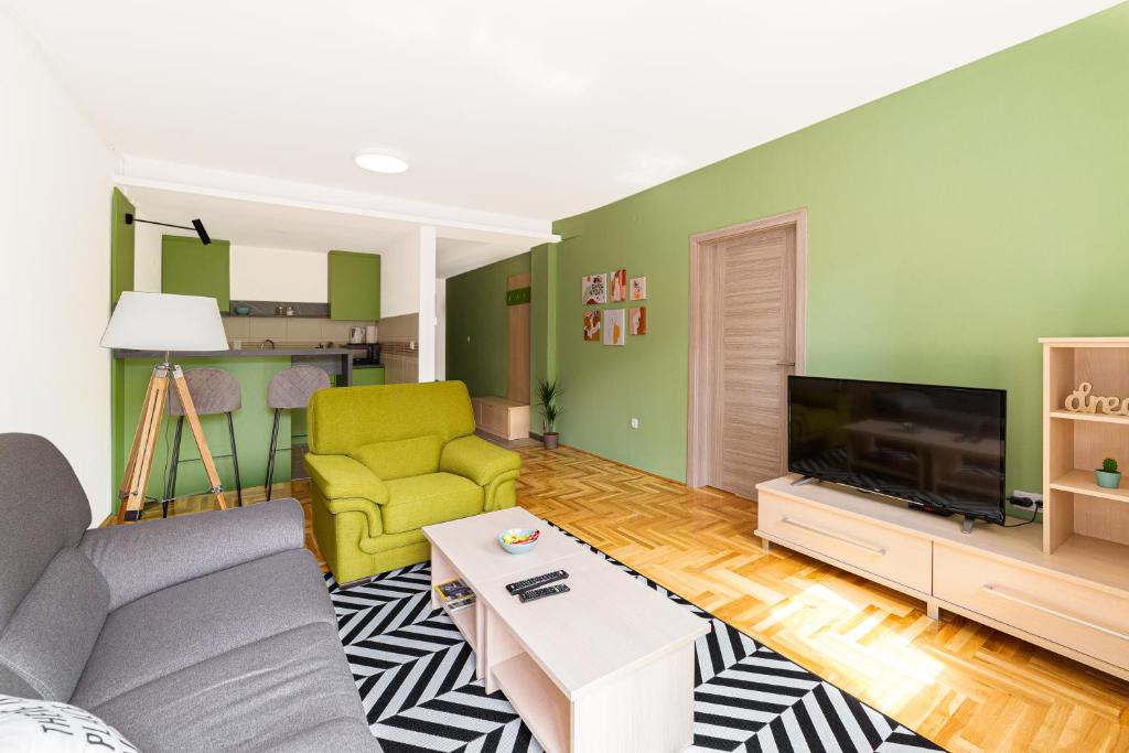 a living room with a couch and a tv at Djokic Apartments in Kragujevac