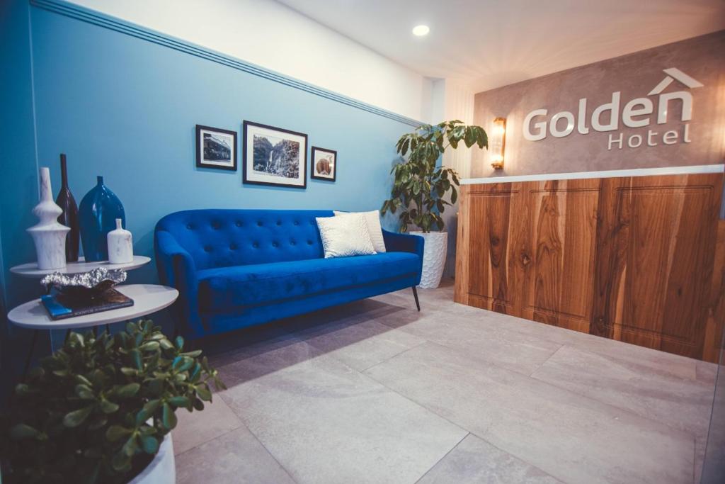 een blauwe bank in een kamer met een hotel bij Golden Hotel in Quevedo