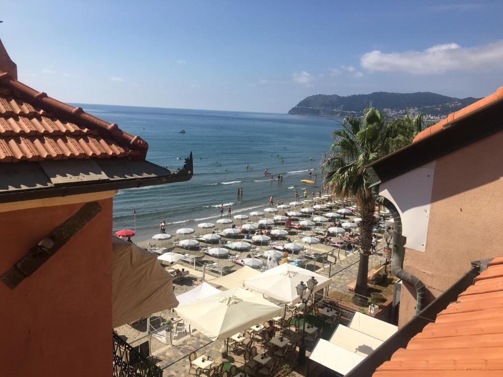 een uitzicht op een strand met parasols en de oceaan bij Casa dei pescatori in Alassio