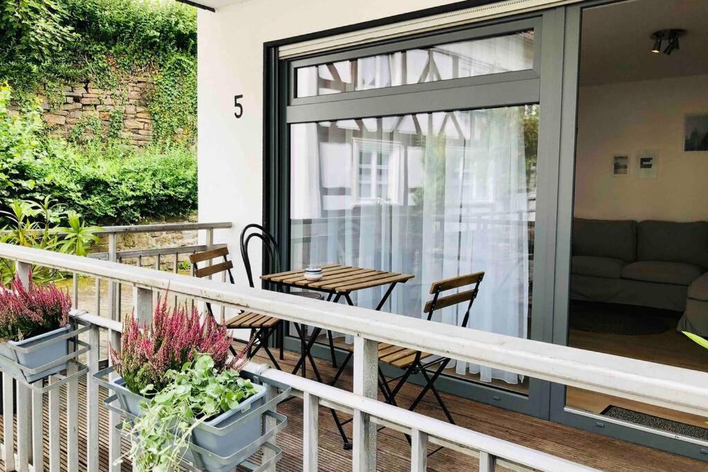 a balcony with a table and chairs and a sliding glass door at Apartment "Alte Mühle" in Wiehl