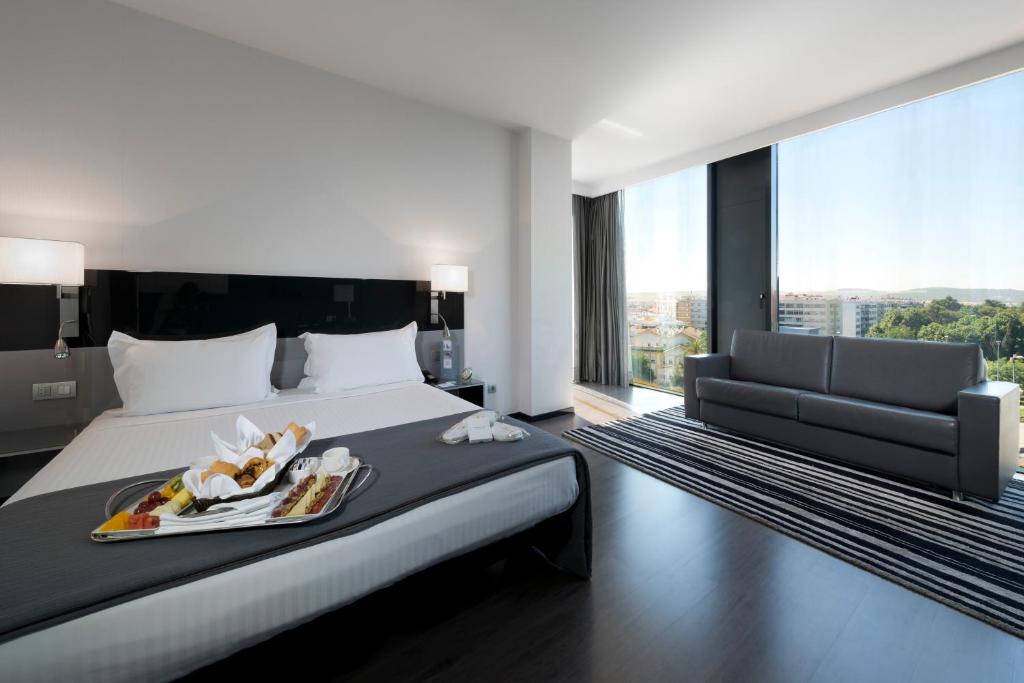 a hotel room with a bed with a tray of food on it at Eurostars Palace in Córdoba