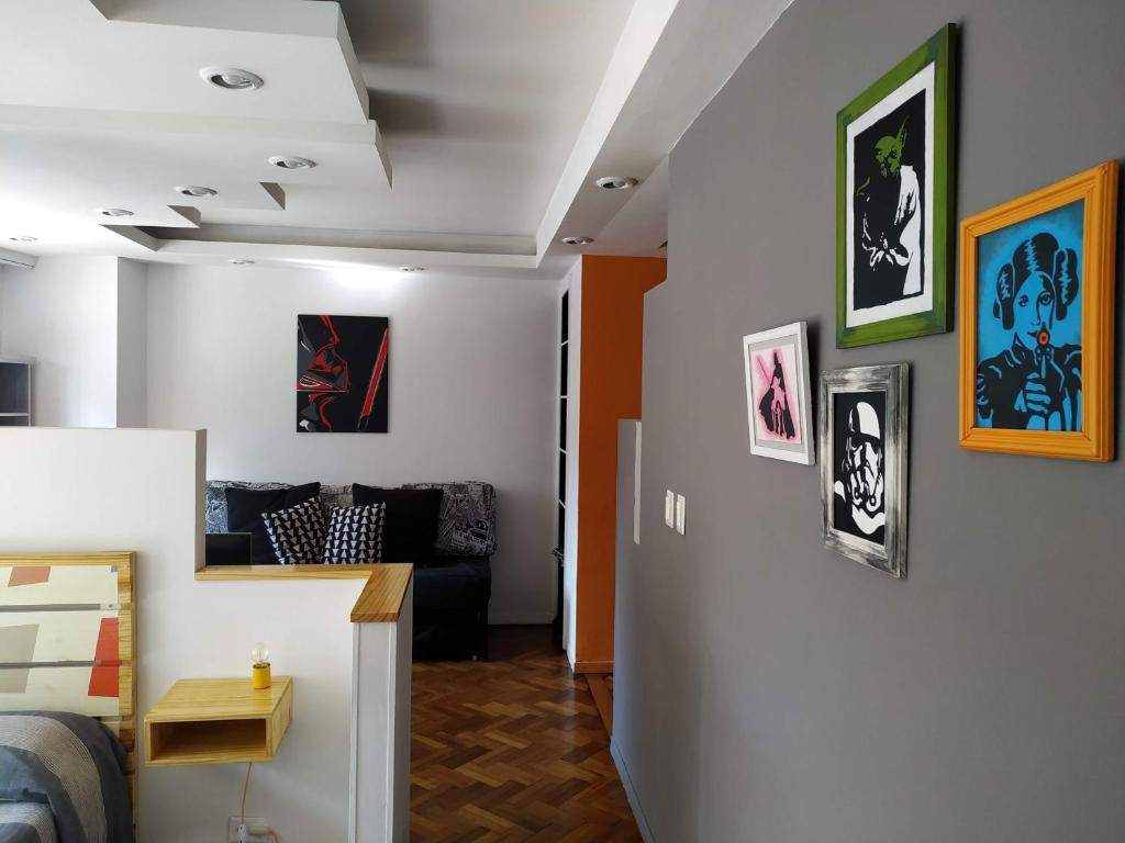 uma sala de estar com um sofá e pinturas na parede em Departamento Unico en Recoleta !! Ubicacion Excelente. em Buenos Aires