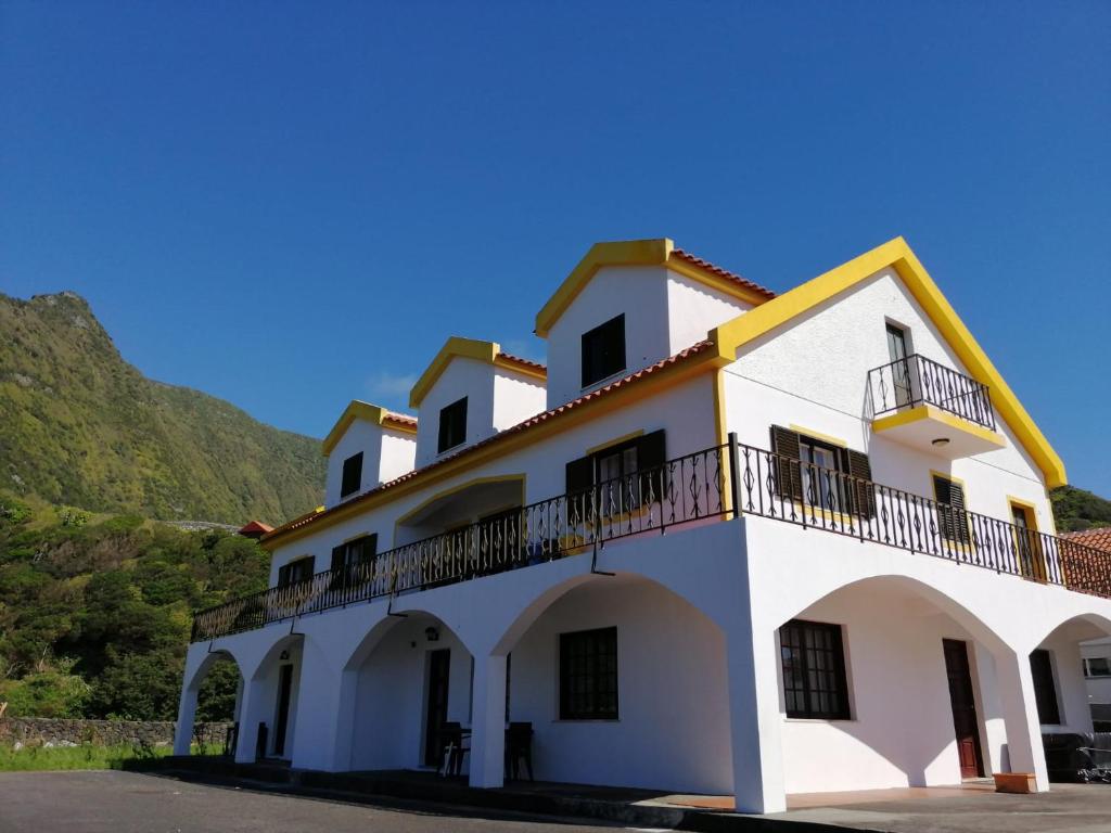 un edificio blanco con balcones y una montaña en Casa da Sogra - Apartamento 1, en Faja Grande