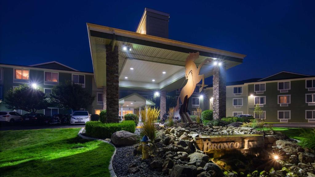 a building with a statue of a giraffe at night at Best Western Bronco Inn in Ritzville