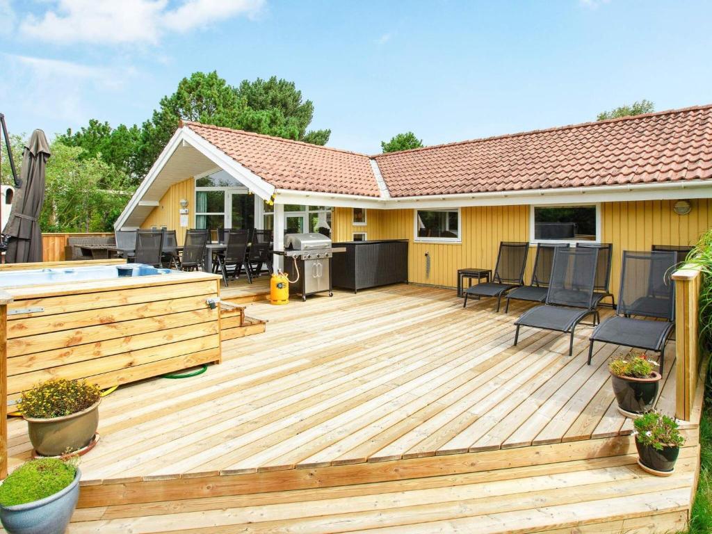 a wooden deck with a pool and a house at 10 person holiday home in V ggerl se in Marielyst
