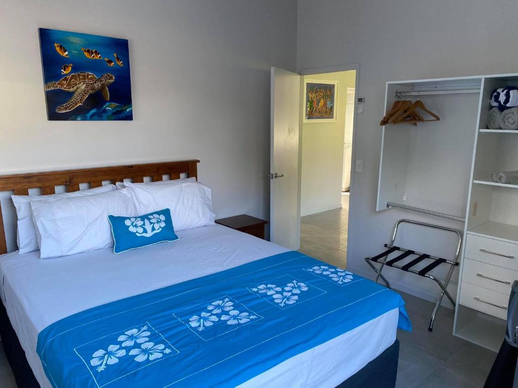 a bedroom with a bed with blue and white sheets at Kaia Villas in Rarotonga