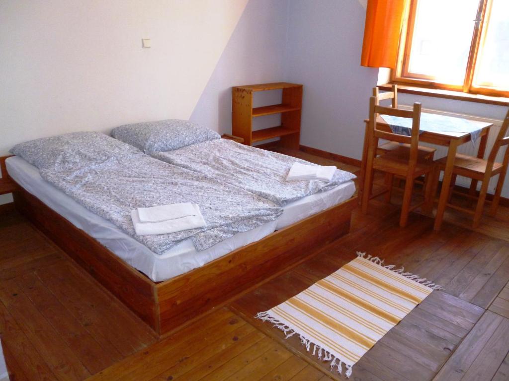 a bedroom with a bed and a table and chairs at Švehlíkova Chata in Nové Hutě