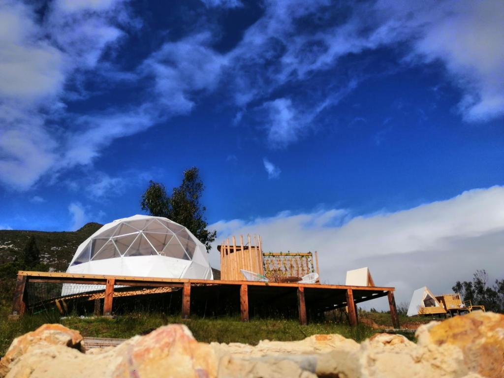 an igloo and chairs sitting on a table in a field at Andes Glamping in Guatavita