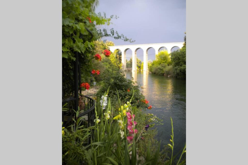 a bridge over a river with flowers at Appartement à FONTAINE DE VAUCLUSE in Fontaine-de-Vaucluse