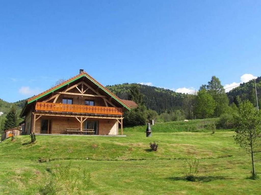 uma cabana de madeira numa colina com um campo verde em Magnificent wooden chalet with sauna em Ventron