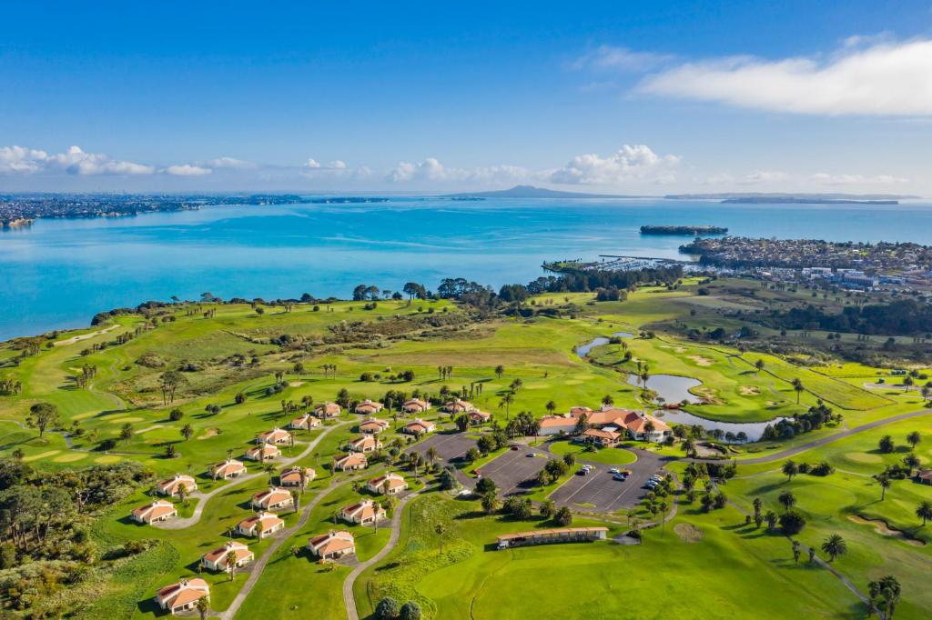 Rydges Formosa Auckland Golf Resort في أوكلاند: اطلالة جوية على ملعب قولف مع المحيط