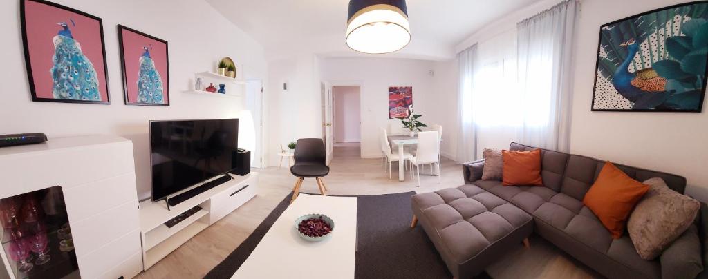 sala de estar con sofá y TV de pantalla plana en ALMERIA SOL Y SUR APARTMENTO - Netflix y Parking GRATUITO, en Almería