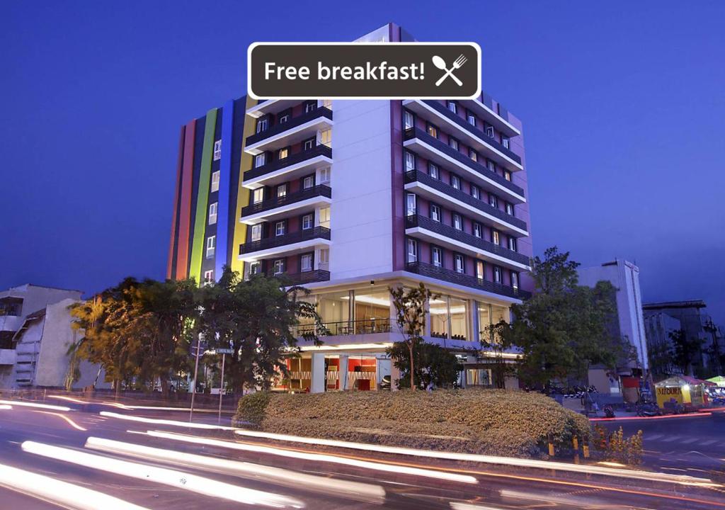 un edificio con una señal de desayuno gratuita delante de él en Amaris Hotel Embong Malang - Surabaya, en Surabaya