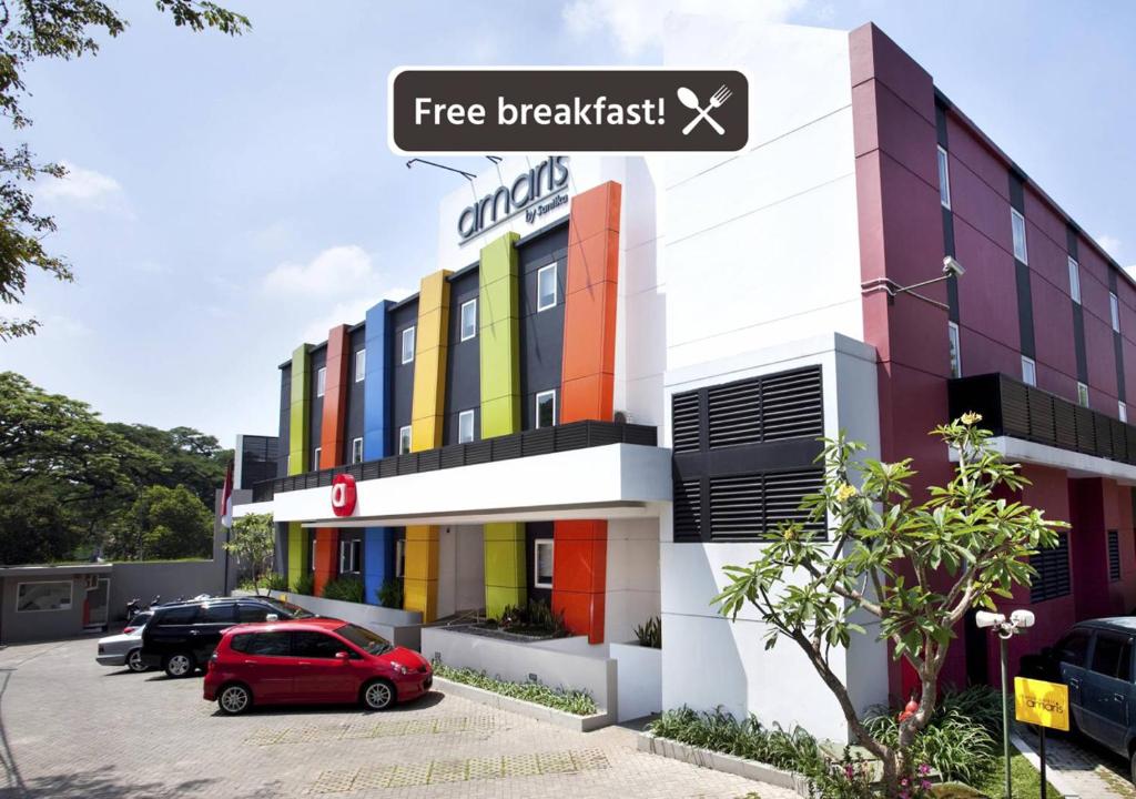 ein Gebäude mit einem roten Auto, das davor geparkt ist in der Unterkunft Amaris Hotel Cimanuk Bandung in Bandung